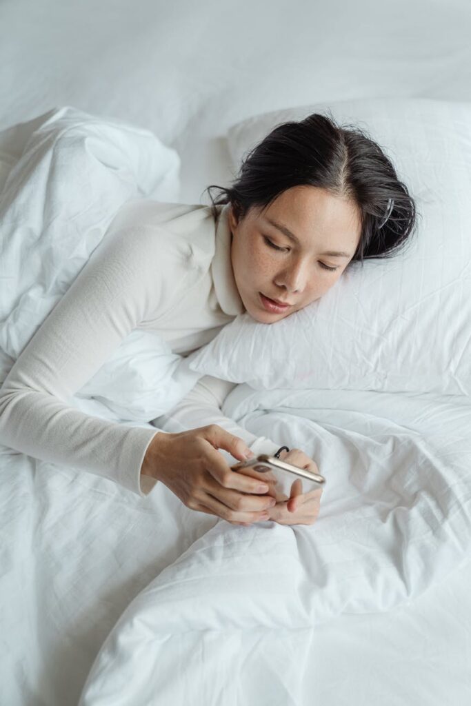 woman with iphone in bed